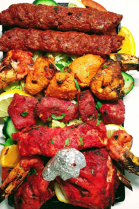 Plat signature de poulet tandoori servi sur un plateau traditionnel dans le meilleur restaurant de Lisieux.